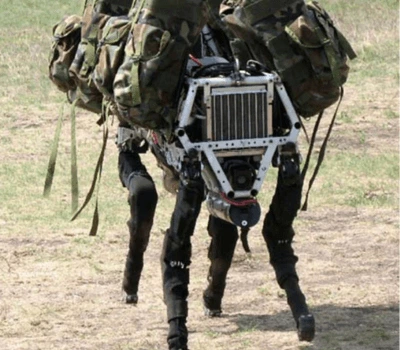 Boston Dynamics' BigDog robot carrying military gear across rough terrain.